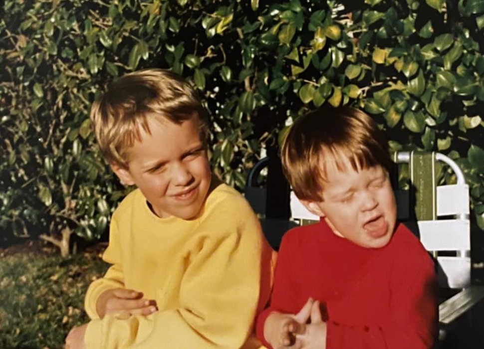 JJ and Andrew Byars as kids, making faces on a backyard bench